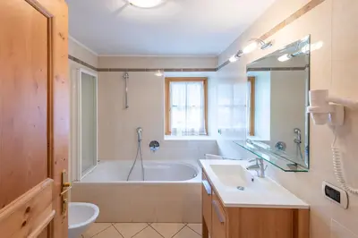 a bathroom with a tub and a toilet and a sink at Residence Bosco Verde in San Cassiano