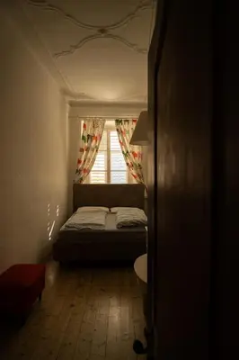 a small bedroom with a bed and a window at Residence Fink Central Apartments in Bolzano