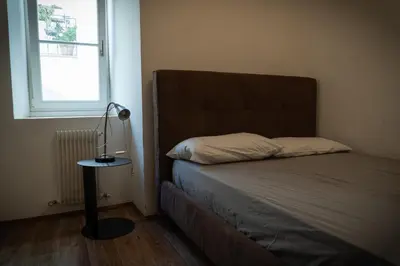 a bedroom with a bed with a lamp on a table at Residence Fink Central Apartments in Bolzano
