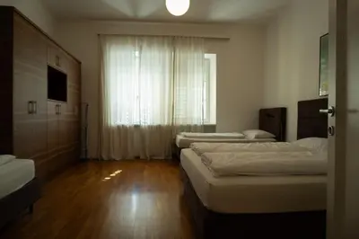 a room with three beds and a window at Residence Fink Central Apartments in Bolzano