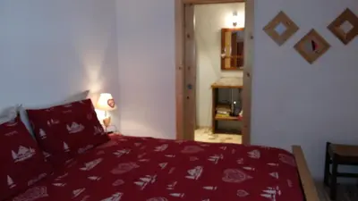a bedroom with a bed with a red blanket at CHALET VILLA RITA in Tesero