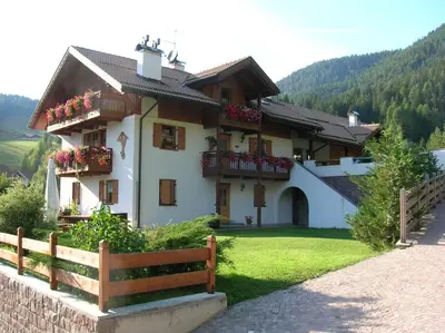 a house with flower boxes and a fence at CHALET VILLA RITA in Tesero