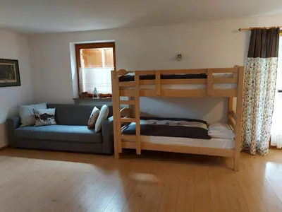 a living room with bunk beds and a couch at CHALET VILLA RITA in Tesero