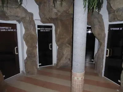a row of doors in a room with fake rocks at Sporthotel Rasen in Rasùn di Sotto