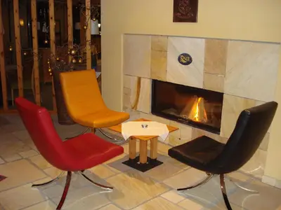 a group of chairs and a table in front of a fireplace at Sporthotel Rasen in Rasùn di Sotto