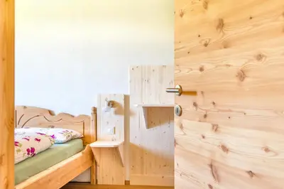 a bedroom with a wooden door and a bed at Tielerhof in Aldino