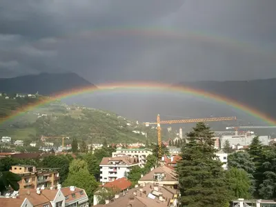 a rainbow over a city with a city at Hotel Lux in Merano