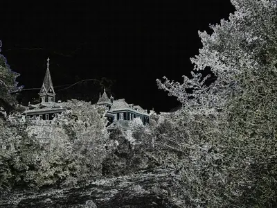 a house with a steeple in the middle of trees at Hotel Lux in Merano