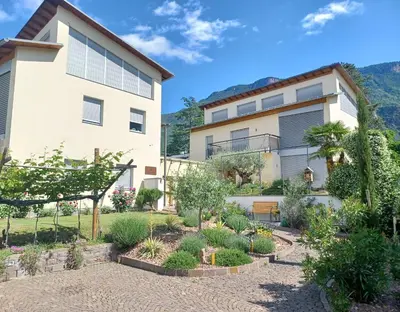 a house with a garden in front of it at Das Landhaus in Terlano