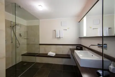 a bathroom with a sink and a shower at Hotel Dolomitenblick in Terento