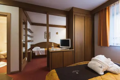 a pair of beds with pillows and towels on them at Hotel Catinaccio in Vigo di Fassa