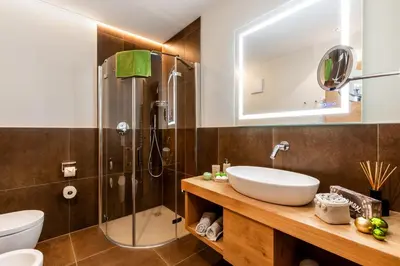 a bathroom with a sink and a shower at Chalets 4 Sorus & Apartments La Villetta in Colfosco