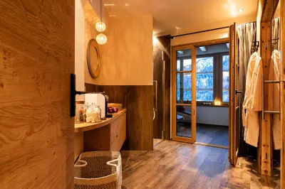 a bathroom with wooden walls and a wooden floor at Chalets 4 Sorus & Apartments La Villetta in Colfosco