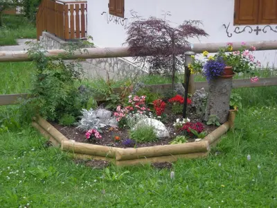 a garden in front of a fence with flowers at Majon del Tisler in Canazei