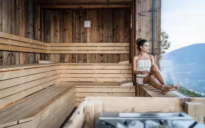 a woman is sitting in a sauna at Chalet in Naturno