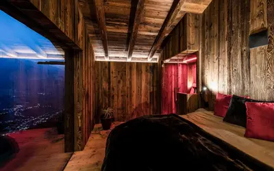 a bedroom with wooden walls and a bed with red pillows at Chalet in Naturno