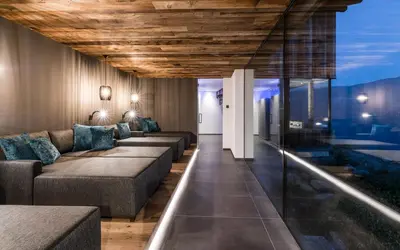 a living room with couches and a glass wall at Chalet in Naturno