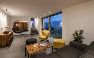 a living room with a couch and a table and chairs at Chalet in Naturno
