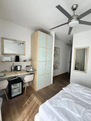 a bedroom with a bed and a desk and a fan at B&B Mele d'Oro in Bolzano