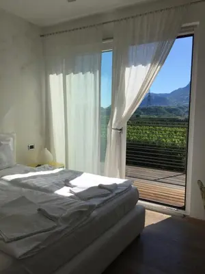a bedroom with a bed and a large window at B&B Mele d'Oro in Bolzano