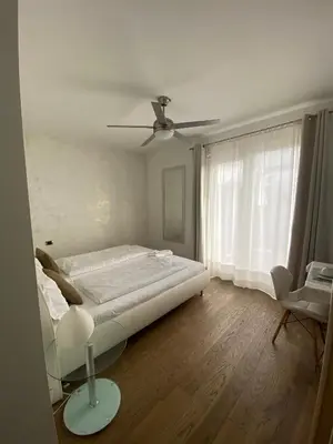 a bedroom with a bed and a ceiling fan at B&B Mele d'Oro in Bolzano