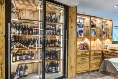 a refrigerator filled with lots of bottles of wine at Hotel Muliac in Selva di Val Gardena