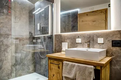 a bathroom with a sink and a shower at Hotel Muliac in Selva di Val Gardena