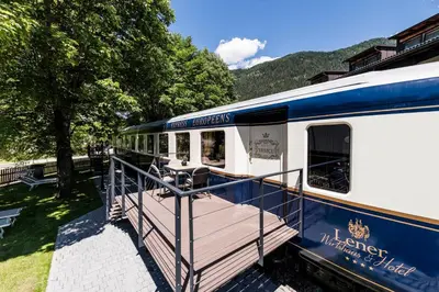 a blue and white train parked at a station at Luxury Lodge - Lener Express in Campo di Trens