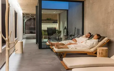 two people laying on a couch in a living room at Luxury Lodge - Lener Express in Campo di Trens