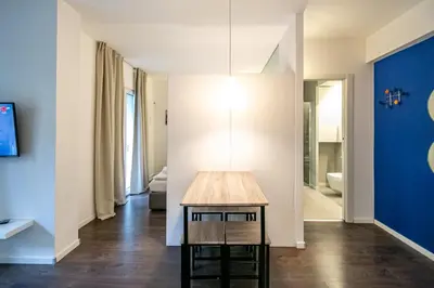 a room with a table and a blue wall at Apartment Vanga in Bolzano