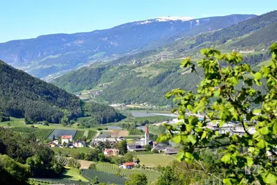 a valley in the mountains with a town and a river at Rumlhof in Bressanone