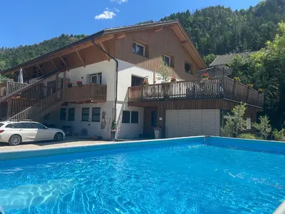 a villa with a swimming pool in front of a house at Rumlhof in Bressanone