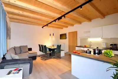 a kitchen and a living room with a couch and a table at Rumlhof in Bressanone