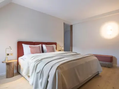 a bedroom with a large bed with pink pillows at Villa Helvetia in Merano