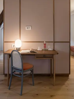 a desk with a chair and a lamp on it at Villa Helvetia in Merano
