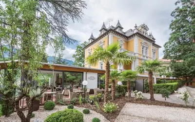 an exterior view of a house with trees at Villa Helvetia in Merano