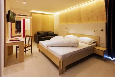 a bedroom with a bed and a table and a couch at Kleinkunsthotel in Naturno