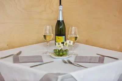 a table with a bottle of wine and two glasses at Kleinkunsthotel in Naturno