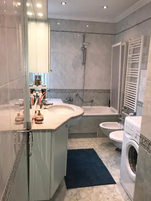 a bathroom with a sink and a washing machine at Appartements Arnica in Ortisei