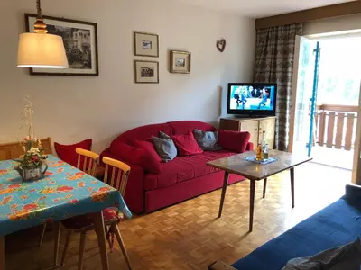 a living room with a red couch and a table at Appartements Arnica in Ortisei