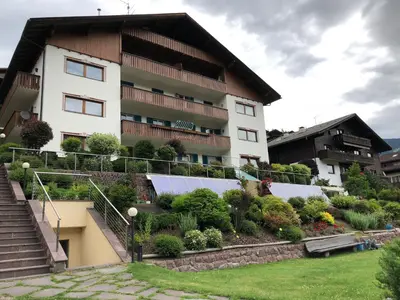 a building with a garden in front of it at Appartements Arnica in Ortisei