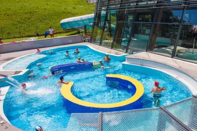 a group of people swimming in a swimming pool at Appartements Arnica in Ortisei