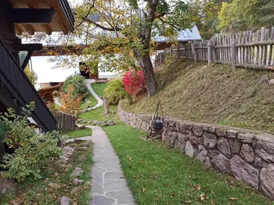 a stone retaining wall next to a yard at Burgerhof in San Genesio Atesino