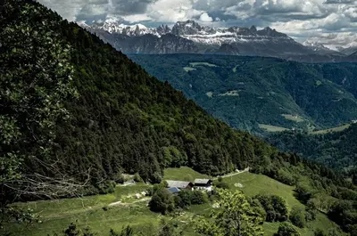 a house in the middle of a valley with mountains at Burgerhof in San Genesio Atesino