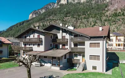 an apartment building with a mountain in the background at Suàn Hotel in Ziano di Fiemme