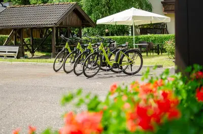 a row of bikes parked next to a table and an umbrella at Suàn Hotel in Ziano di Fiemme