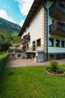 a large house with a lawn in front of it at Suàn Hotel in Ziano di Fiemme