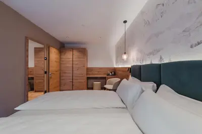 a bedroom with a large white bed in a room at Suàn Hotel in Ziano di Fiemme