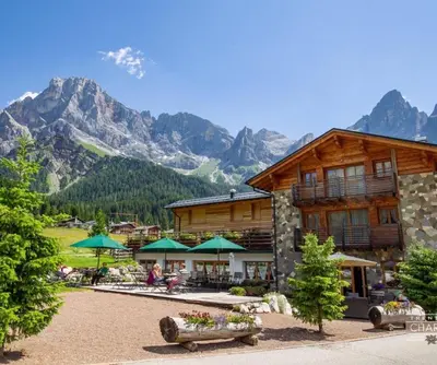 a ski lodge with mountains in the background at Chalet Prà delle Nasse in San Martino di Castrozza