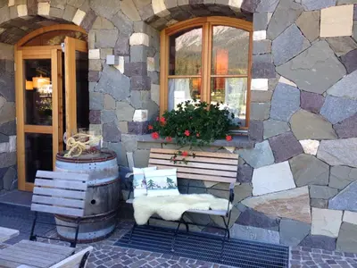 a stone building with a bench and a window at Chalet Prà delle Nasse in San Martino di Castrozza
